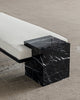 Detail image of bench showing cube nero marquina marble base, blackened steel structure and beige boucle fabric upholstered mattress.